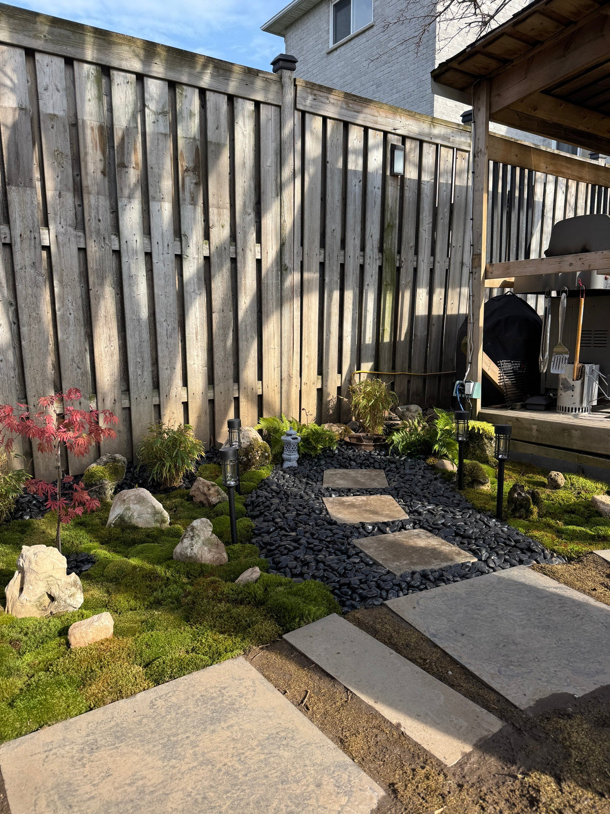 Stepping-stone path edged with live moss and black river rock